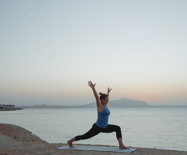 A silhouette of a woman stretching during sunrise, symbolizing energy and well-being.